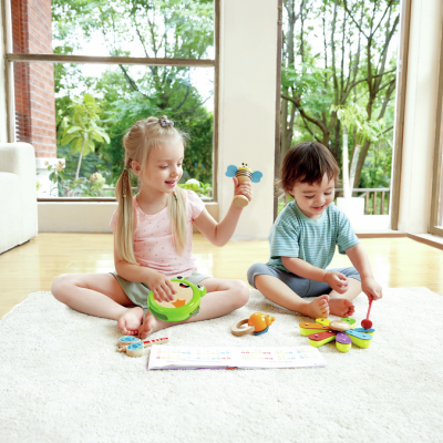 Crianças a brincar com brinquedos de madeira coloridos num tapete branco