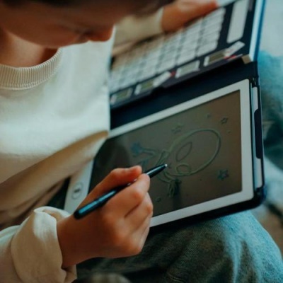 Criança a desenhar um alienígena numa tablet com caneta digital