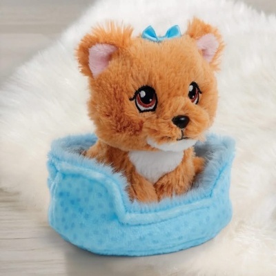 Peluche de gatinho castanho claro numa cama azul felpuda