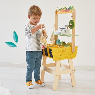 Criança a brincar com supermercado de madeira e caixa registadora