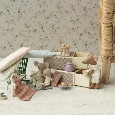 Bonecos de rato em tecido com móveis de brinquedo em ambiente com papel de parede floral