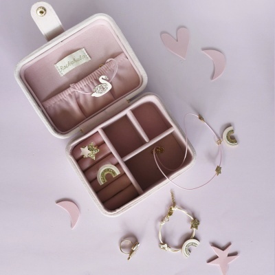 Estojo de joias rosa claro com joias e pendentes de estrela e arco-íris