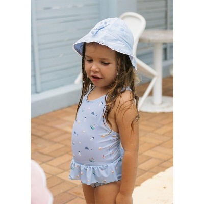 Menina com fato de banho azul claro e chapéu azul