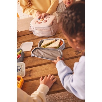 Crianças ao redor da mesa com lancheiras e caixas de alimentos