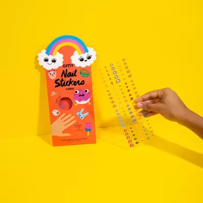 Pacote laranja de autocolantes para unhas com desenhos kawaii e mão a segurar tira transparente com autocolantes.