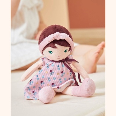Boneca de pano com vestido rosa e padrão floral sentada