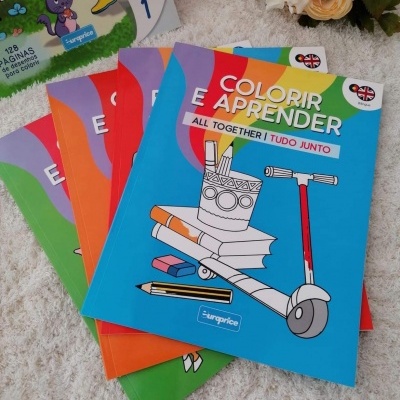 Quatro livros colorir e aprender empilhados em superfície branca