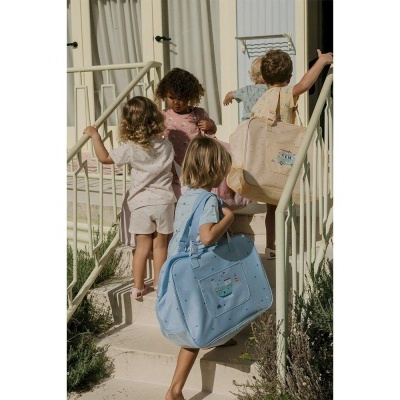 Crianças sobem escada exterior carregando mochilas de tecido coloridas