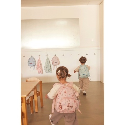 Crianças com mochilas infantis em espaço interior claro