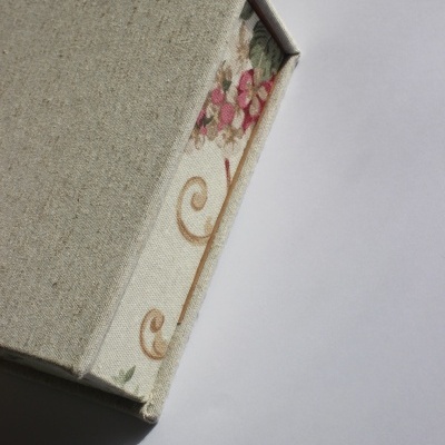 Caixa de tecido bege com padrão floral visível