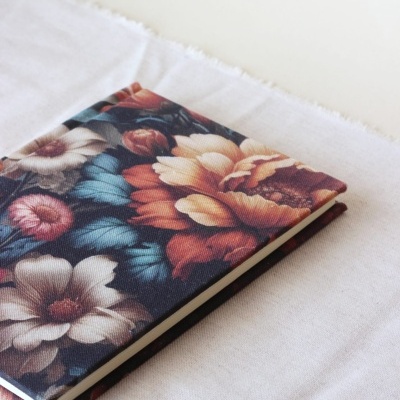 Caderno com capa de tecido floral colorido sobre pano branco