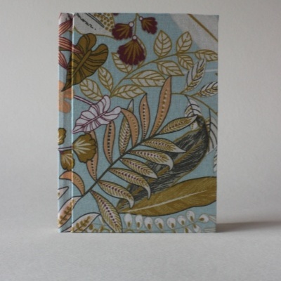 Capa de livro ou agenda com padrão floral e folhas em tecido colorido