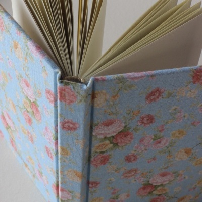 Caderno floral com capa de tecido azul claro e páginas abertas