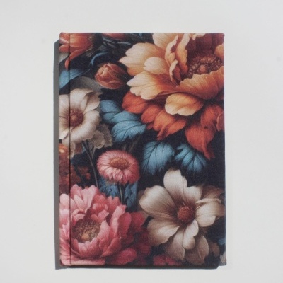 Capa de livro floral em tons salmão, branco, azul e rosa sobre fundo escuro