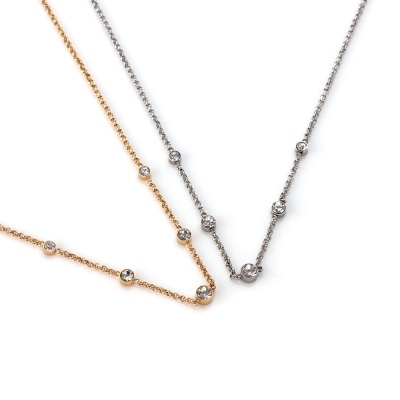 Dois colares finos, um dourado e outro prateado, com pedras brilhantes espaçadas.