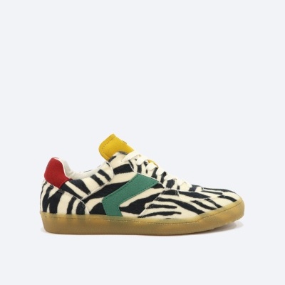 Ténis com padrão zebra em preto e branco com detalhes em verde, vermelho e amarelo