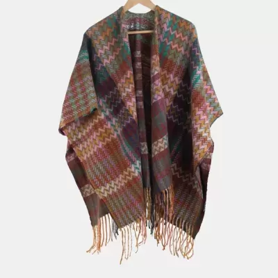 Poncho colorido com padrão zig-zag pendurado num cabide