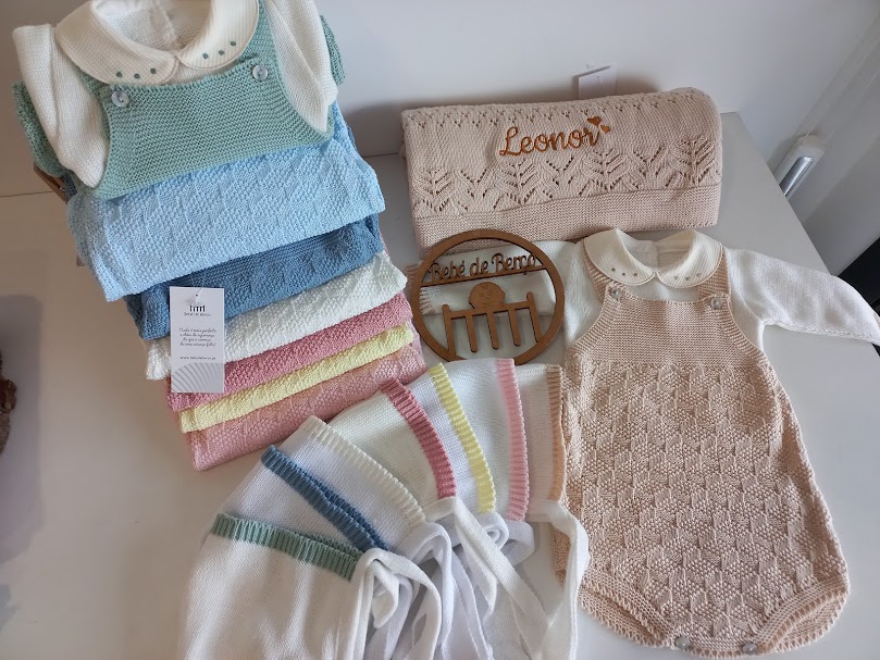 Conjunto de roupa de bebé em malha colorida com babete e saco com nome bordado