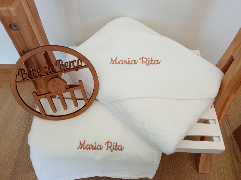 Toalhas brancas com nome bordado e placa de madeira com texto