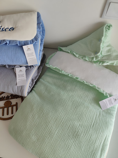 sacos de dormir ou mantas para bebé em verde, azul com bordado e cinza, etiquetas visíveis