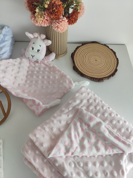 Toalha de banho de bebé rosa com capuz de animal de peluche e flores artificiais ao fundo