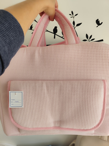 Mala cor-de-rosa com alças e bolso frontal, decorada com parede branca e vinis pretos de pássaros e folhas