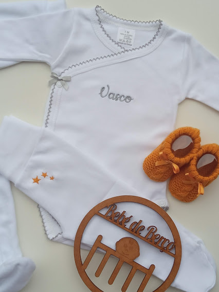 Conjunto de roupa de bebé branco com bordados e botins laranja