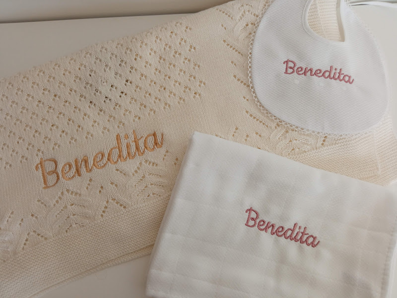 Conjunto de cobertor bege rendado, babete branca e fralda branca com nome Benedita bordado.