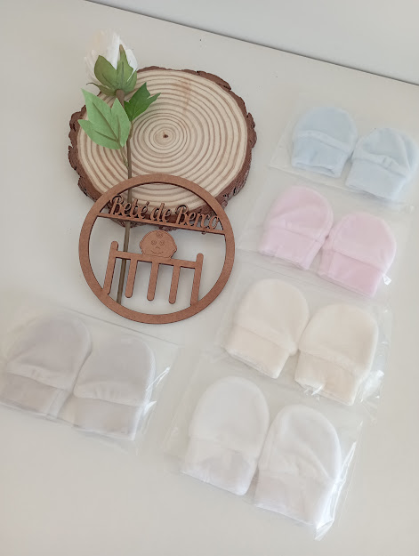 Luvas de bebé em várias cores com tábua e decoração de madeira