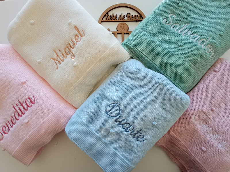 Toalhas de algodão em várias cores com nomes bordados e padrões de corações.