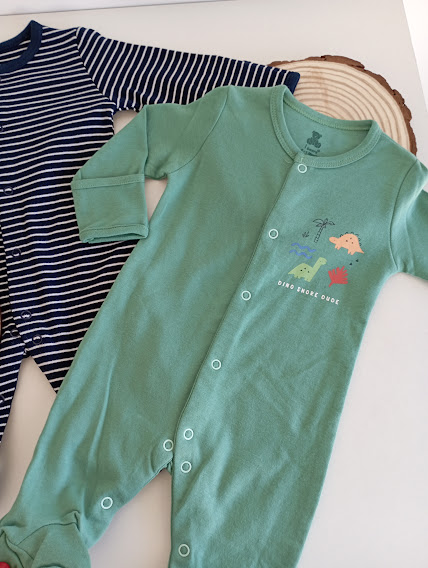 Dois pijamas de bebé, azul às riscas e verde com estampado de dinossauros
