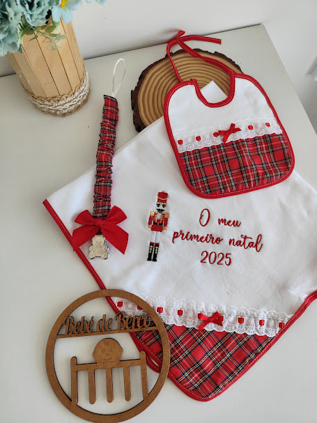 Conjunto de babete, toalha, chupeta decorada e quadro de madeira para bebé em padrão xadrez e texto 'O meu primeiro natal 2025'