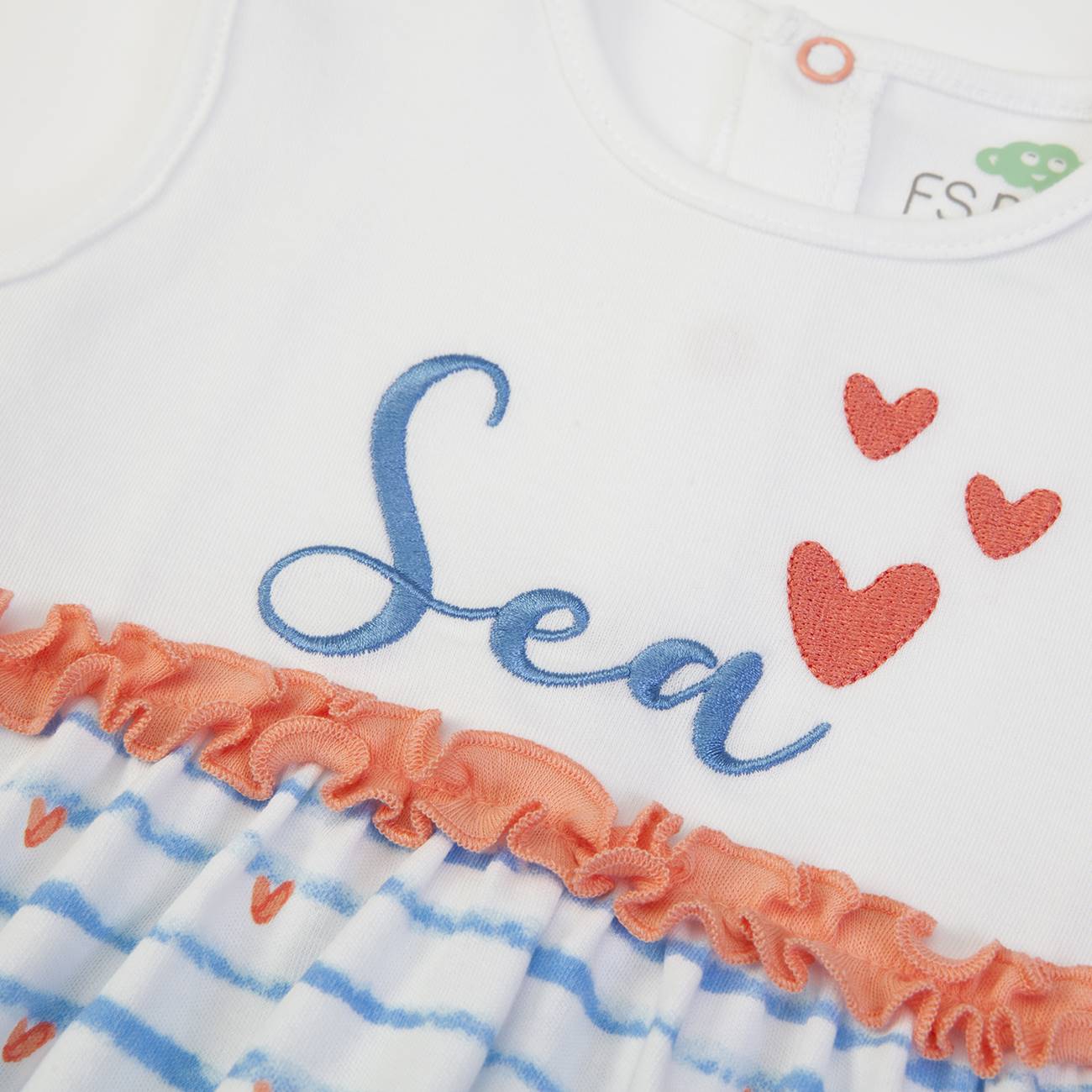 Vestido de bebé branco com listras azuis, corações vermelhos e folhos cor-de-rosa.