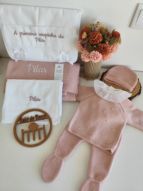 Conjunto de roupa de bebé rosa claro em malha com bordados, arranjo de flores e fralda bordada