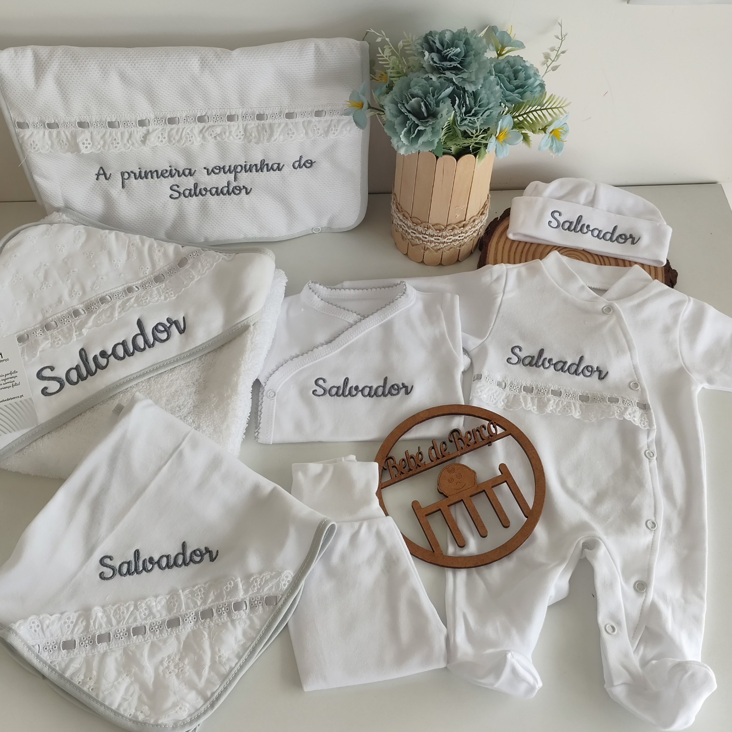 Conjunto de roupa de bebé branco com bordados com o nome Salvador e bolsa bordada