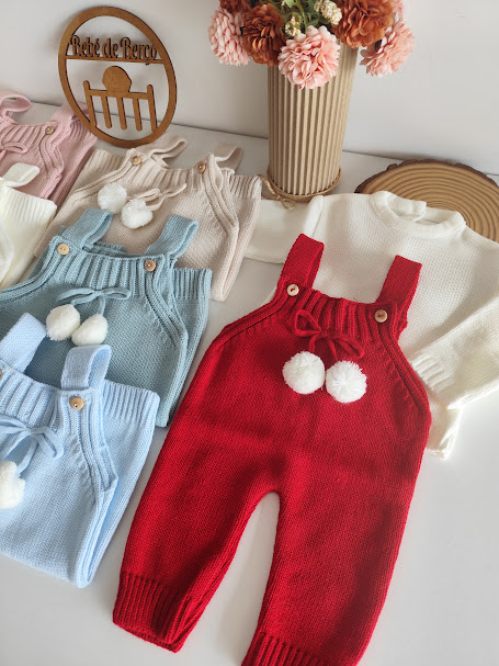 Conjunto de jardineira e camisola de bebé em malha colorida com pompons.