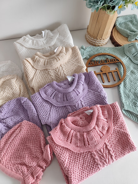 Conjunto de roupas de bebé em malha colorida com gola frisada e padrão trançado