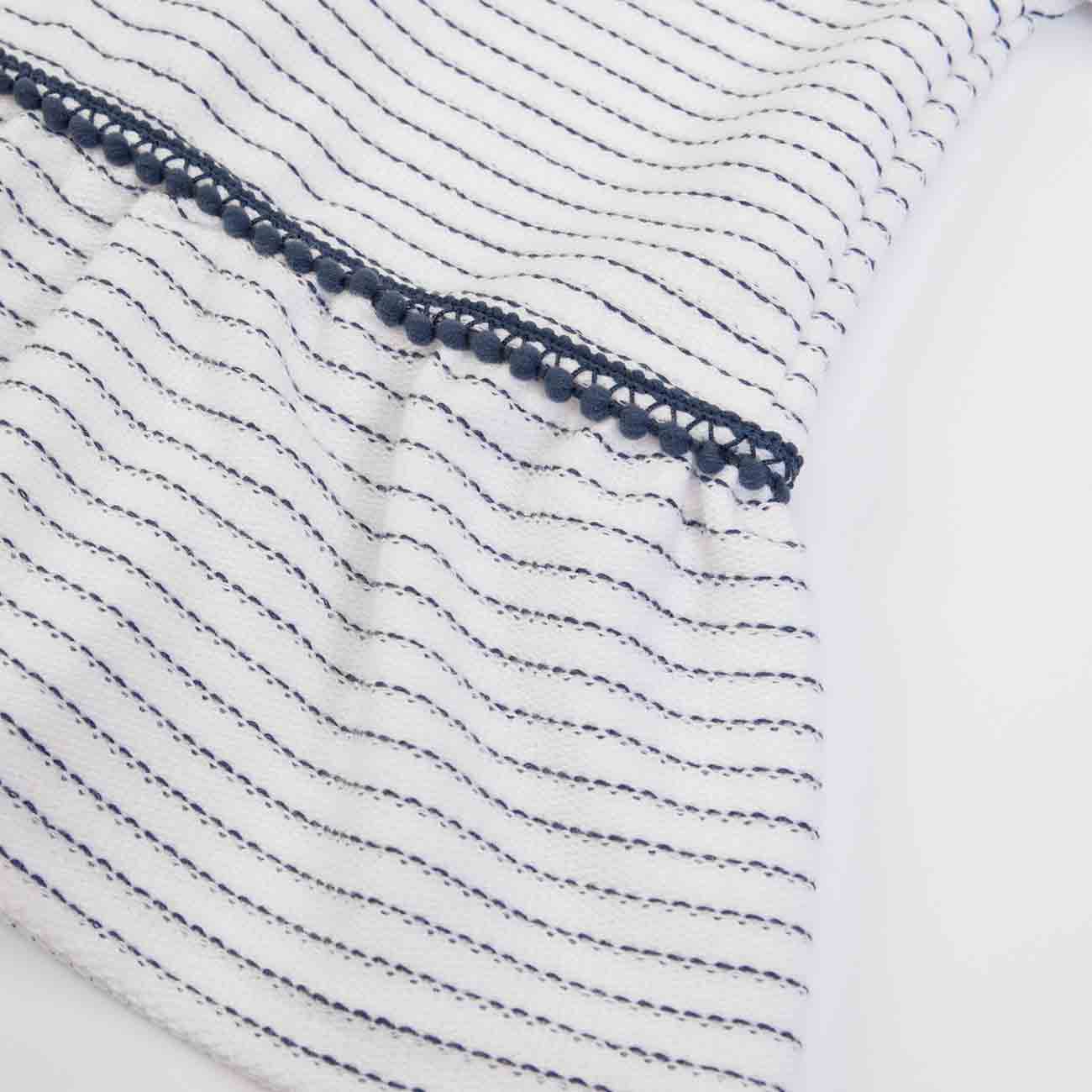 Tecido branco com riscas azuis e detalhe em renda azul escuro.