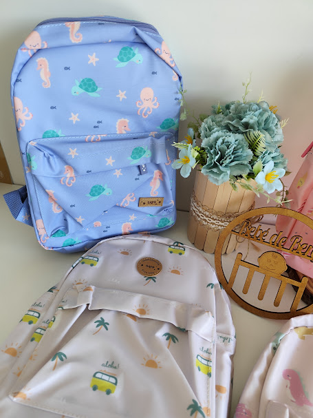 Mochilas de tecido coloridas com padrões marítimos e de caravanas, vaso de flores e placa decorativa de madeira