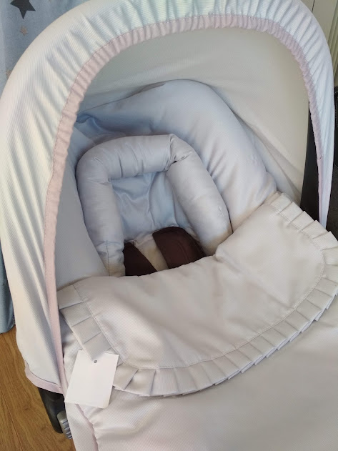 Carrinho de bebé com capota branca, interior cinza claro e cobertor cinza claro