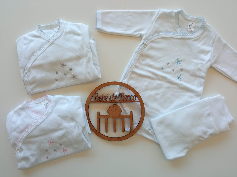 Conjunto de roupa de bebé branca com estrelas e objeto decorativo de madeira