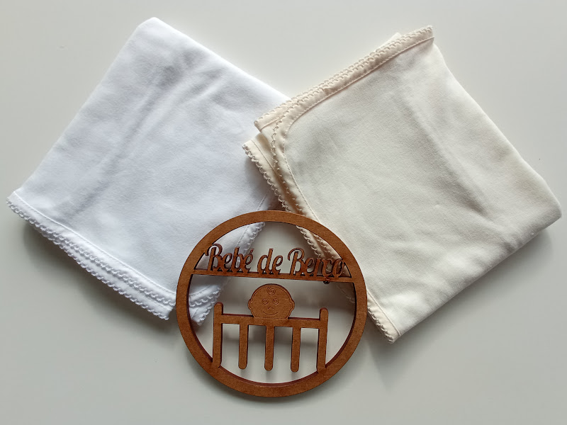 Lenços de tecido branco e creme com objeto decorativo de madeira com texto Pé de Bicho