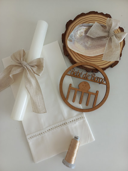 Conjunto decorativo com vela branca, toalha branca, carimbo de madeira e base de madeira com concha