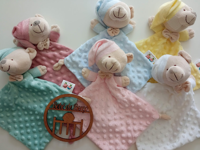 Cinco panos sensoriais em forma de ursinhos de várias cores, texturas e um círculo de madeira gravado