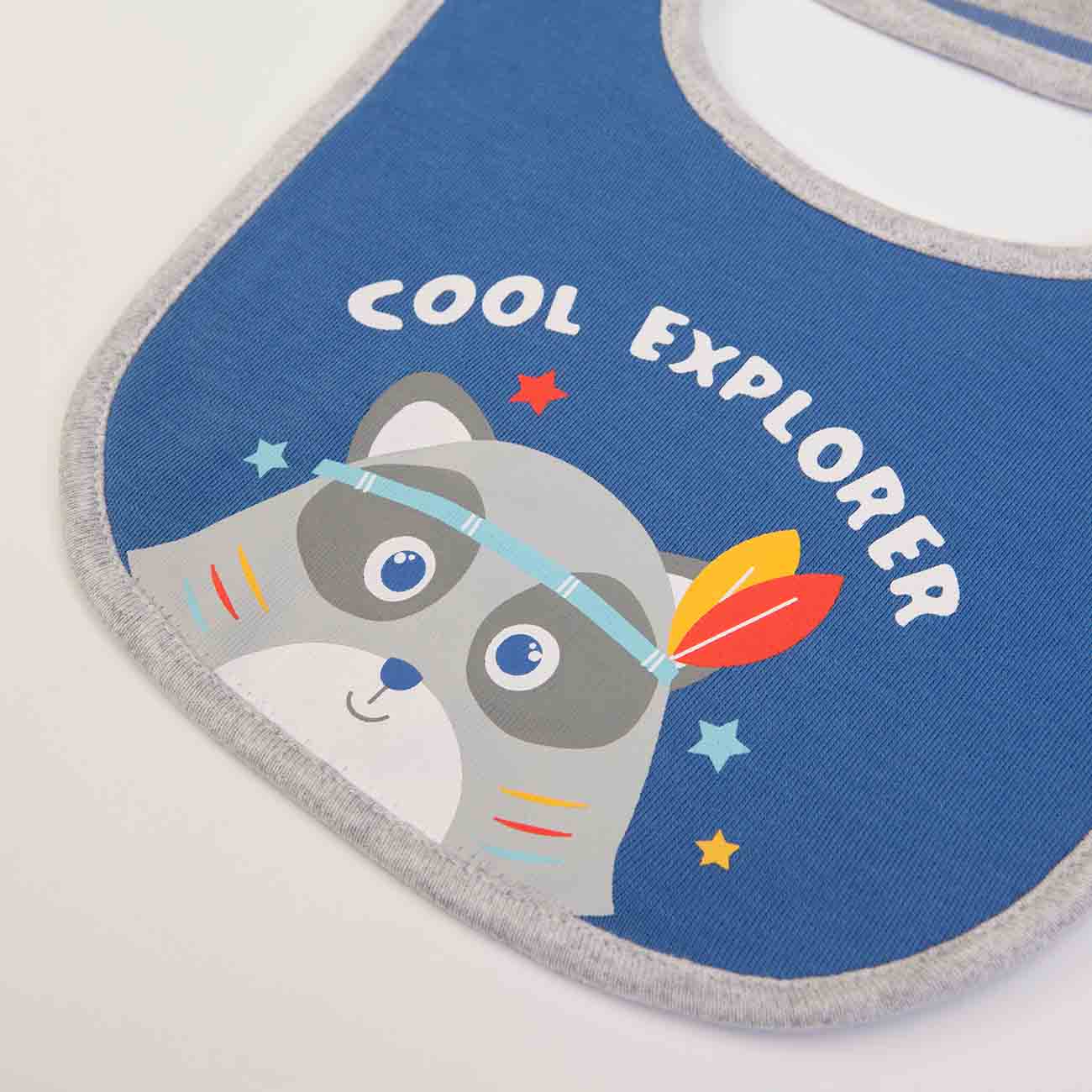 Babete azul com desenho de guaxinim e texto 'COOL EXPLORER'