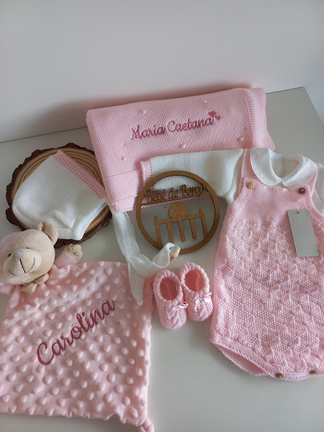 Conjunto de roupa e acessórios de bebê em rosa e branco com mantas bordadas e peluche