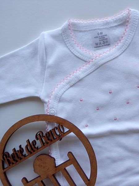 Body branco de bebé com bordados rosa e ornamento de madeira com texto