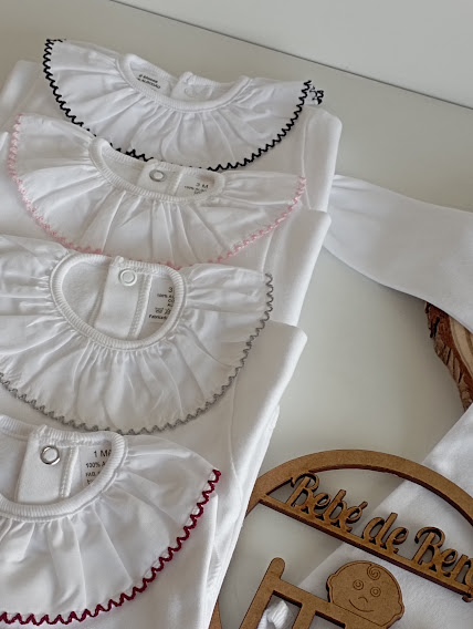 Bodies de bebé brancos com golas em babado e bordados coloridos