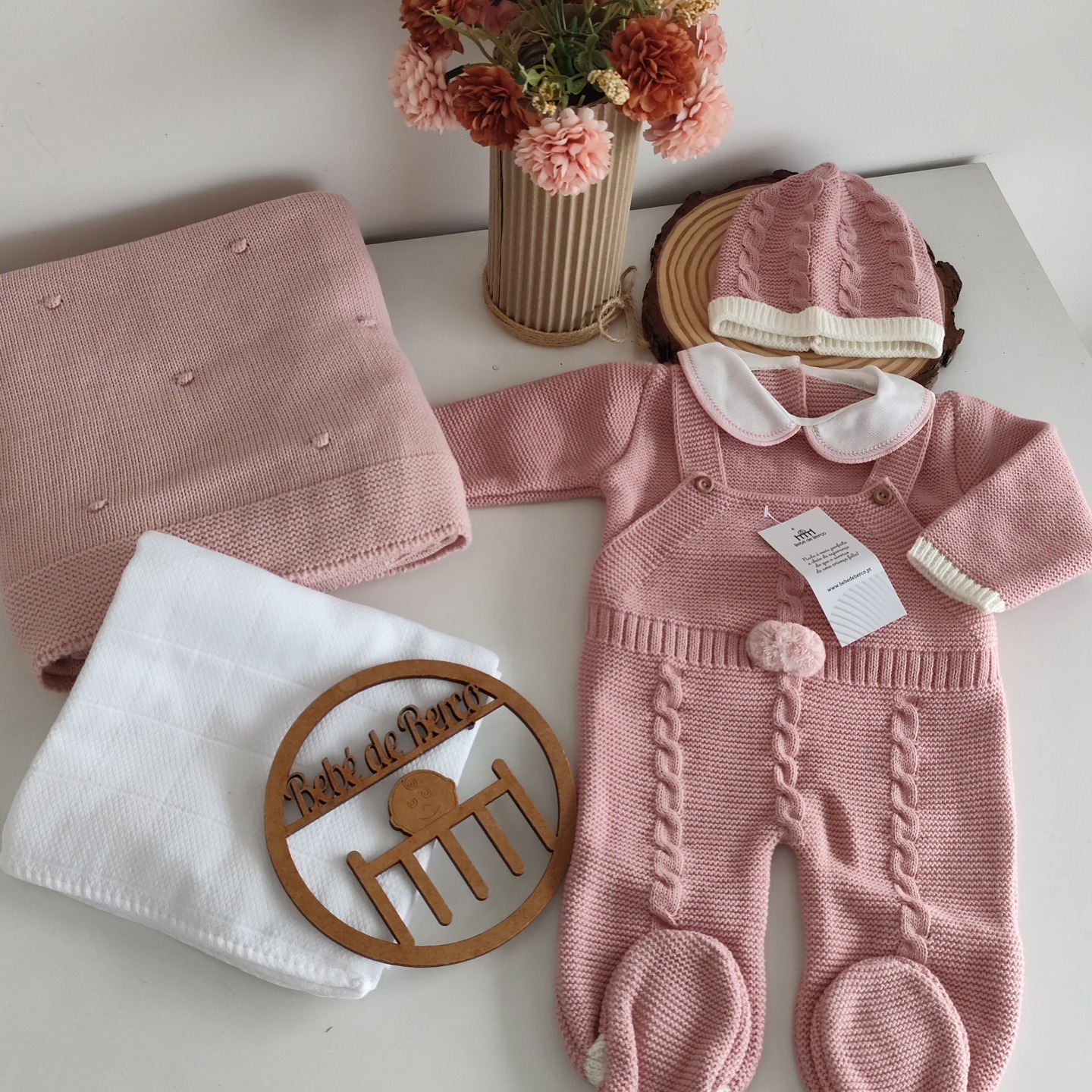 Conjunto de bebé rosa tricotado com gorro, manta, toalha branca e placa de madeira com texto