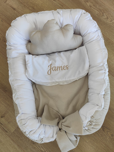 Ninho de bebé bege e branco com almofada de nuvem e bordado James